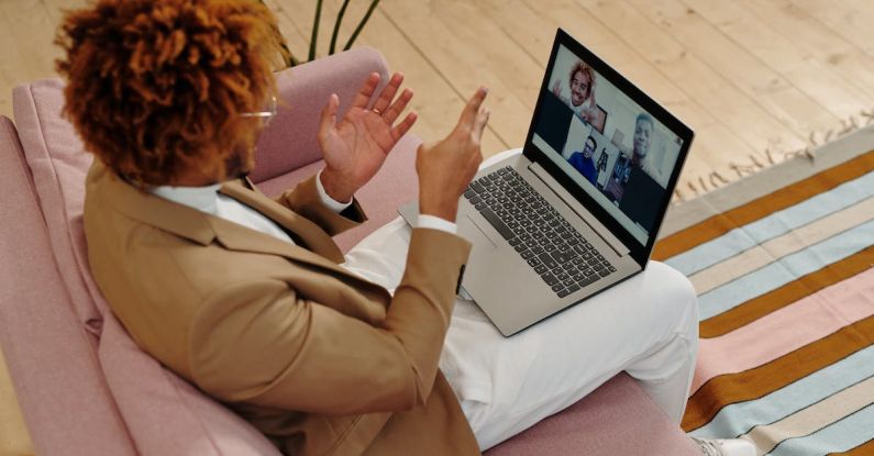 Webcam - Man Sitting on Sofa Talking on Webcam on Laptop