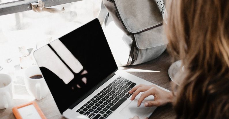 Backup Software - Close-up Photography of Woman Sitting Beside Table While Using Macbook
