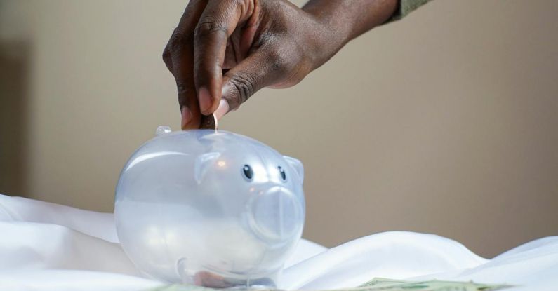 Savings - Person Putting Coin in a Piggy Bank